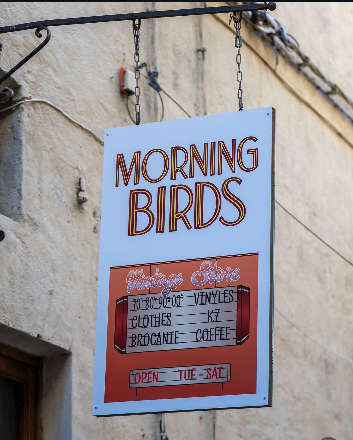 L'enseigne Morning Birds suspendue rue Ranchin — Vintage Store : vinyles, clothes, K7, brocante, coffee, ouvert du mardi au samedi.